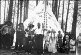 San Poil chief Jim James 
in ceremonial dress stands 
with others by his tipi