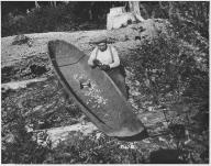 Quinault man using plane 
to smooth side of canoe near 
Lake Quinault, Washington